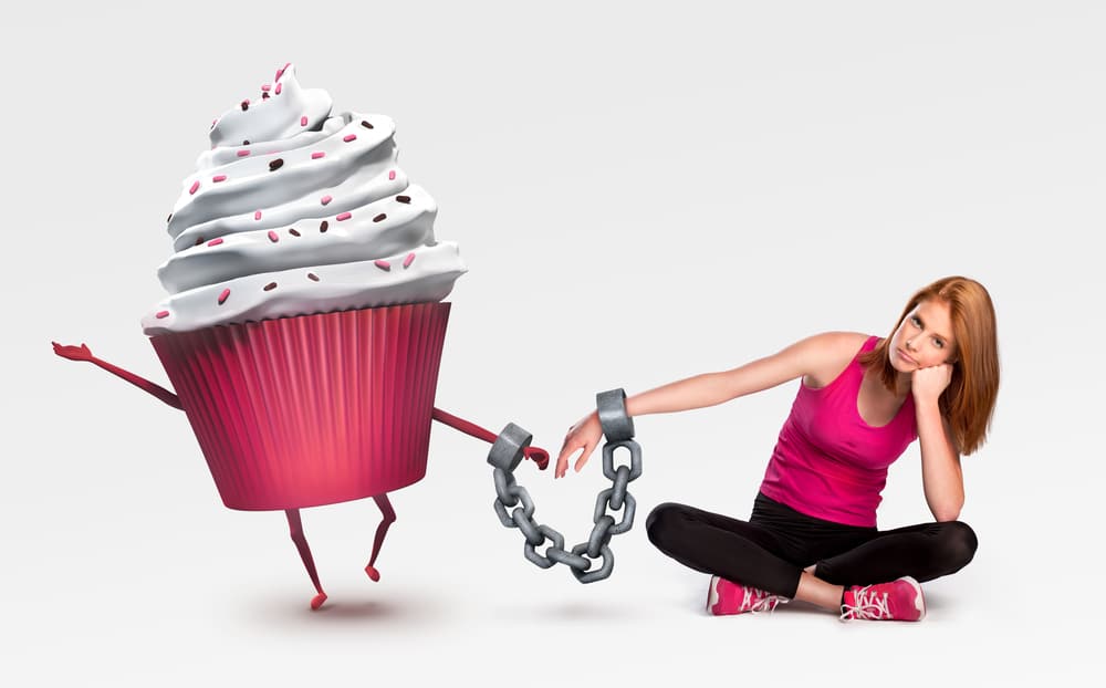 Mulher acorrentada a um cupcake