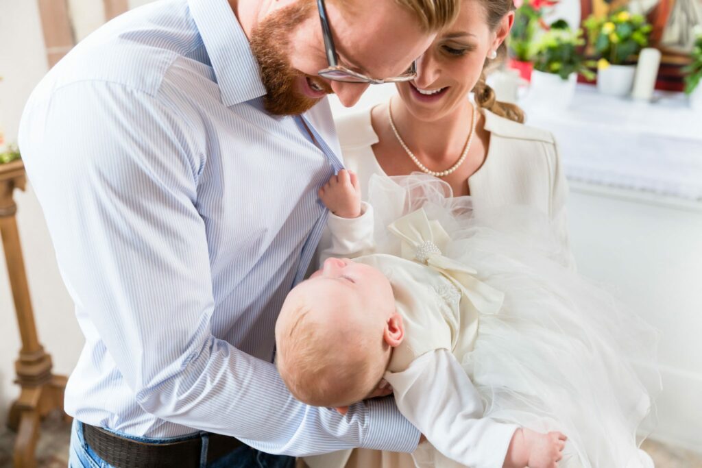 Casal segurando bebê durante batizado