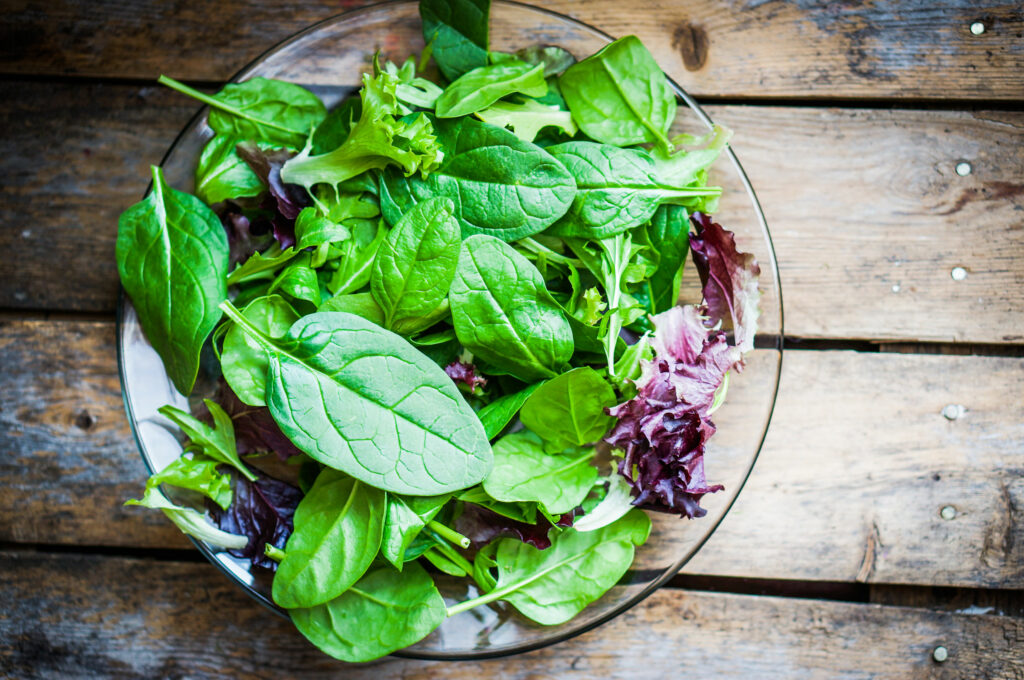 Salada em um recipiente de vidro em uma mesa de madeira