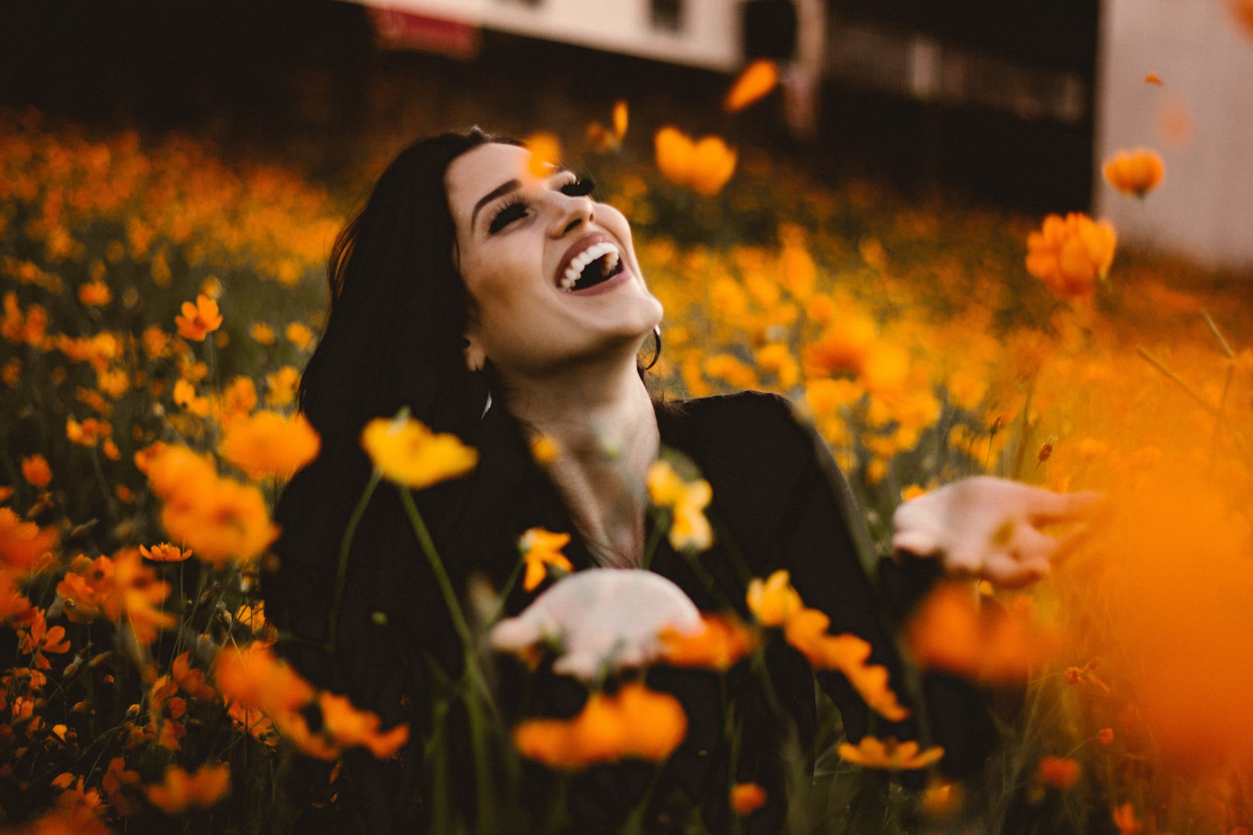 Mulher sorrindo em campo de flores.