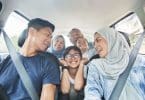 Família asiática dentro de um carro.