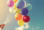 Pessoa segurando vários balões coloridos