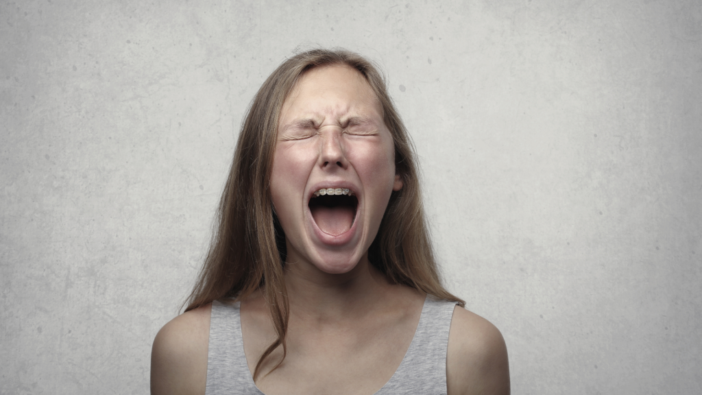 Imagem de uma menina gritando de raiva