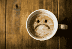 Xícara com café com carinha triste desenhado
