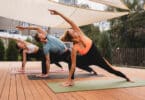 Três pessoas fazendo Yoga juntos ao ar livre, num deck