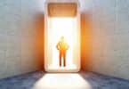 Homem em frente à uma porta iluminada. Conceito de destino