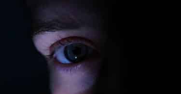 Imagem do olho de uma pessoa no escuro, como se estivesse se escondendo