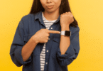 Mulher apontando para relógio de pulso, estilo Smartwatch, em seu braço.