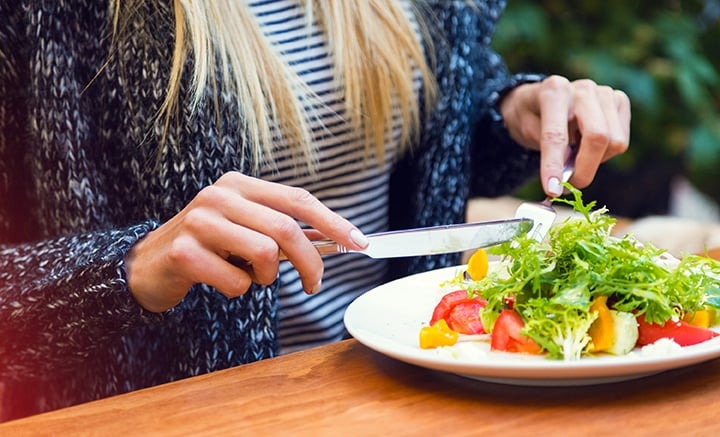 Mulher comendo salada