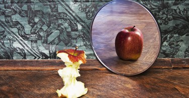 imagem surrealista de uma maçã refletida no espelho