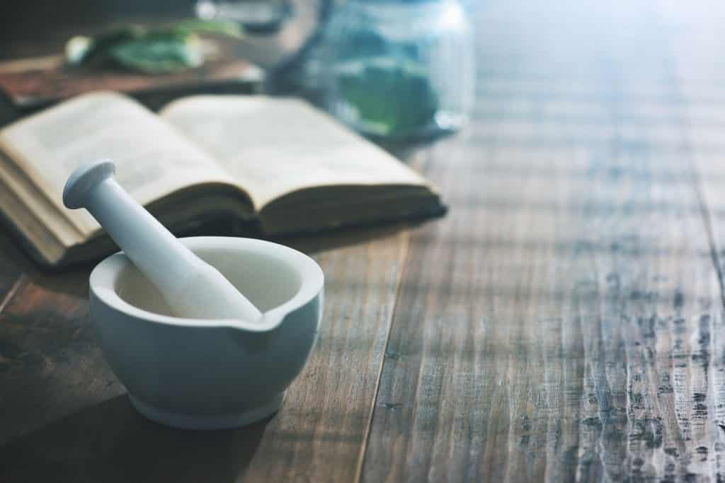 Potinho ao lado de um livro em uma mesa