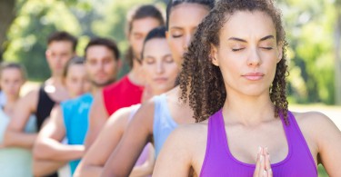 Mulheres uma atrás da outra fazendo yoga