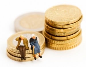 Bonequinhos de idosos sentados em moedas