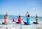 Pessoas fazendo meditação em grupo na praia