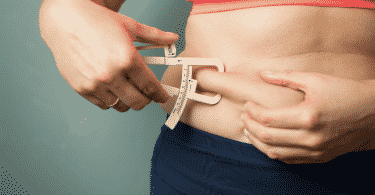 Mulher medindo a gordura na barriga
