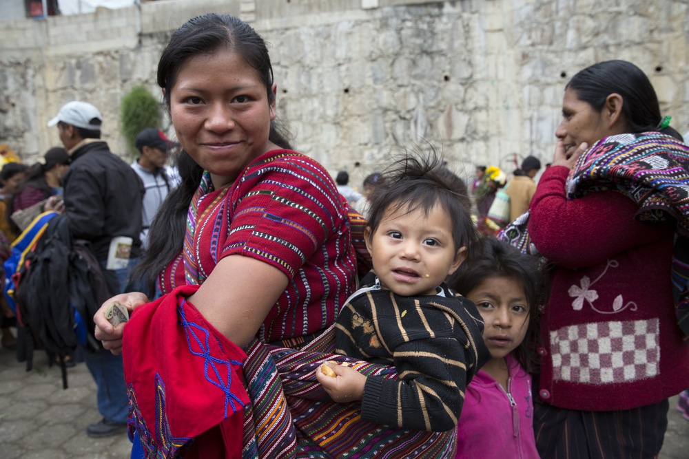 Fila de guatemalas/os com crianças