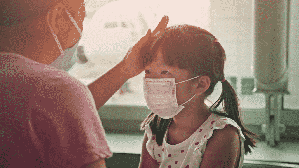 Mãe medindo a febre da filha com a mão