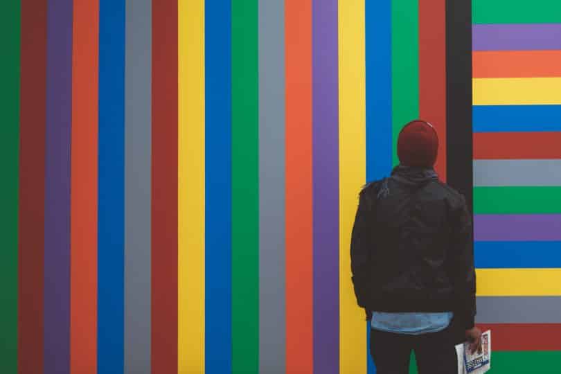 Homem olhando para parede colorida a sua frente