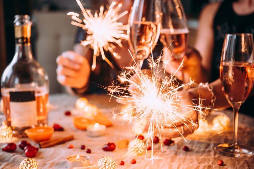 Pessoas ao redor da mesa com velas acesas e taças de champanhe