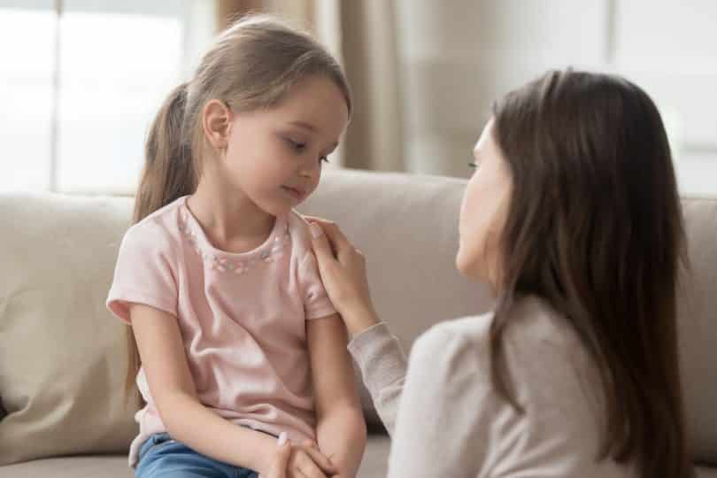 Mulher branca consolando menina branca.