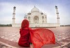 Mulher sentada de costas com Taj Mahal ao fundo