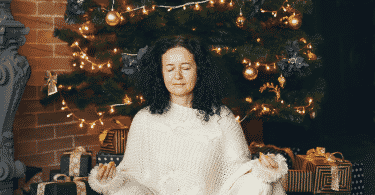 Mulher meditando embaixo da árvore de natal