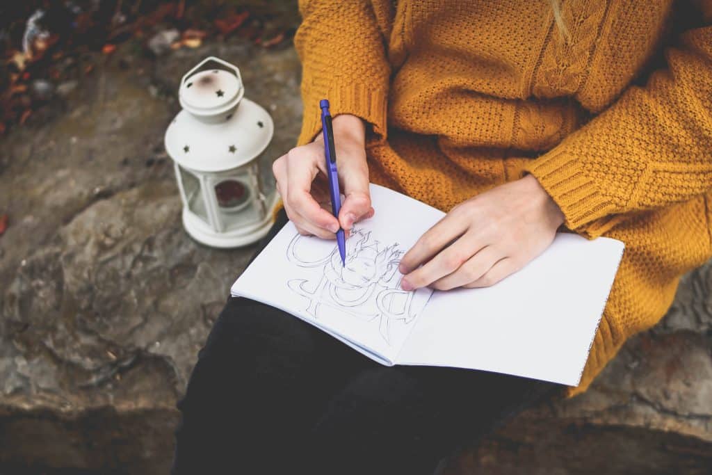 Mulher desenhando em um caderno