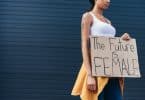 Mulher segurando cartaz escrito em inglês "o futuro é feminino"