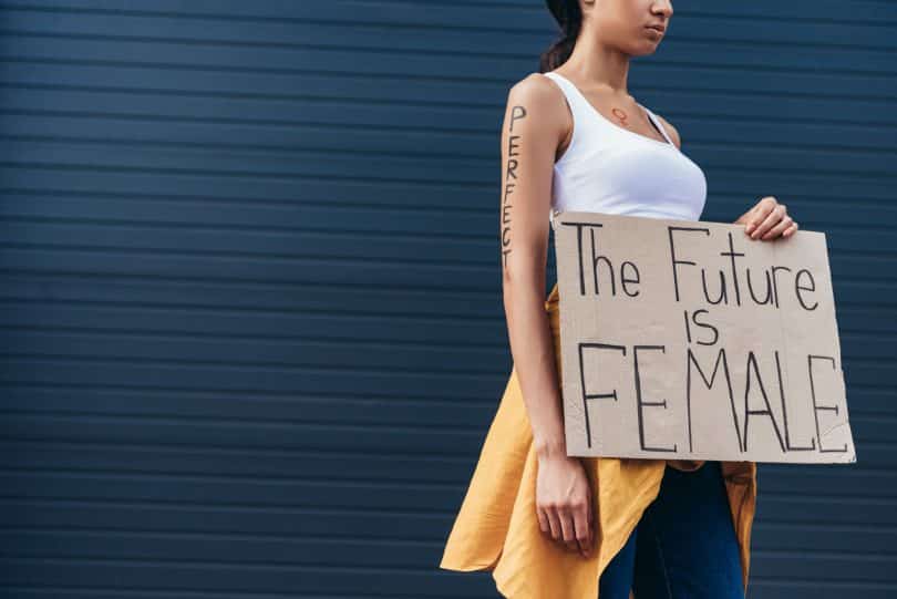 Mulher segurando cartaz escrito em inglês "o futuro é feminino"