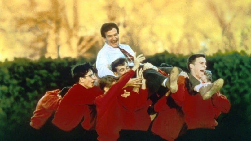 Capa do filme Sociedade dos Poetas Mortos, com o professor protagonista, John Keating, sendo carregado por seus alunos.