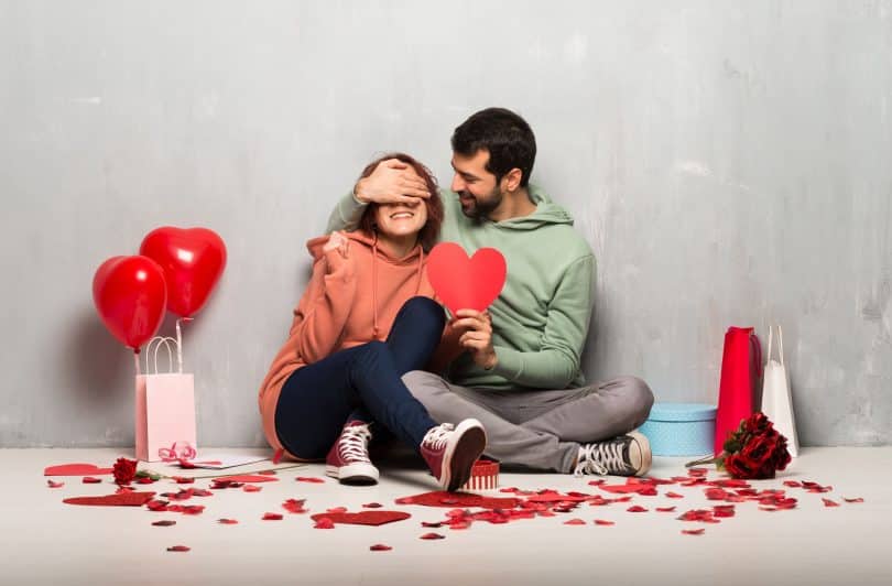 Casal no Dia dos Namorados segurando um símbolo de coração.