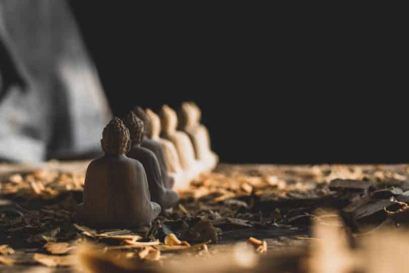 Seis estátuas de madeira de Buda em fila.