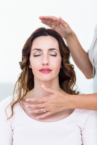 Calm woman receiving reiki treatment on white background