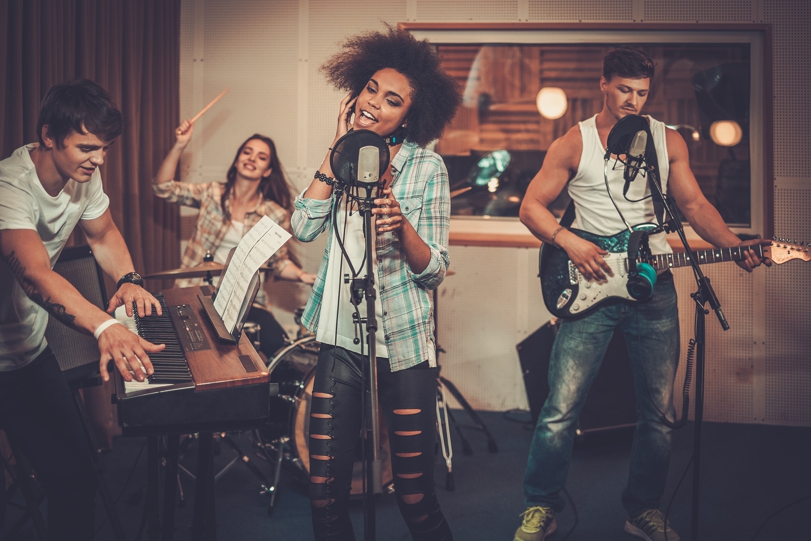 Multiracial music band performing in a recording studio