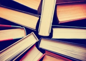 image of a stack of hard back books on the end of the pages toned with a retro vintage warm instagram like filter app or action effect