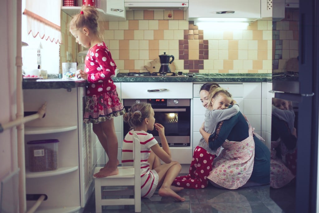 Mother with three kids cooking holiday pie in the kitchen to Mothers day, casual lifestyle photo series in real life interior