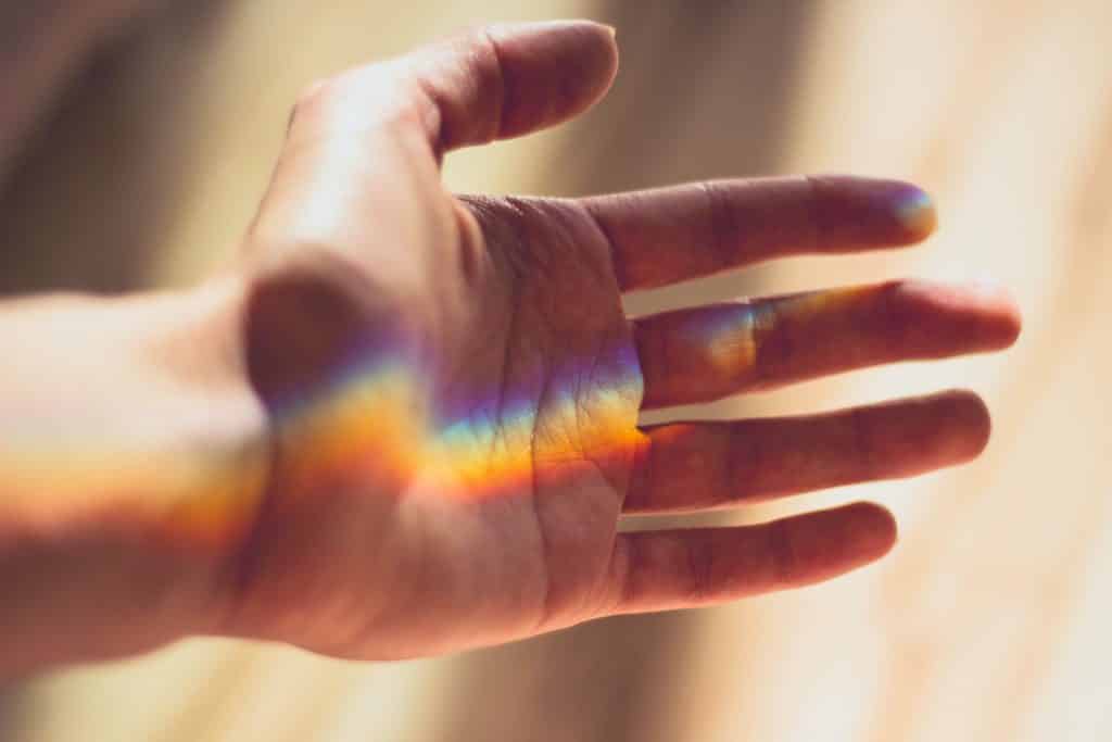 Mão com reflexo de um arco iris