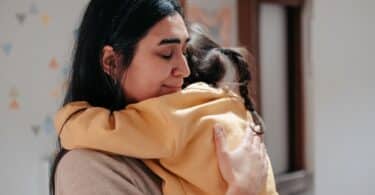 Mãe abraçando sua filha com expressão de emoção