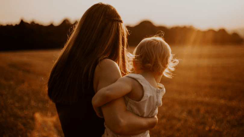 Mãe com bebê no colo.