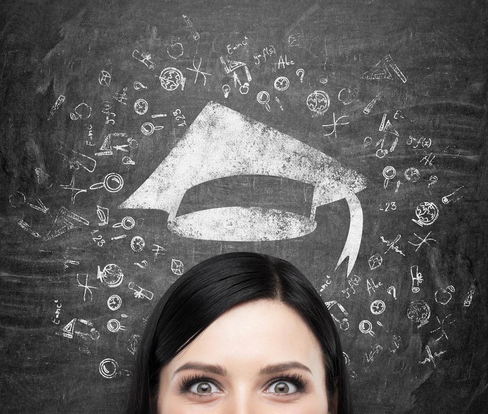 A head of young brunette lady who is thinking about university education. Drawn educational icons and a graduation hat on the black chalkboard background .