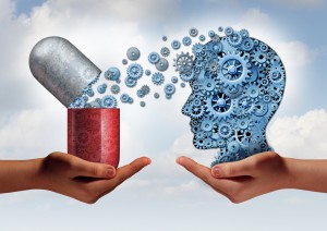 Brain medicine mental health care concept as hands holding an open pill capsule releasing gears to a human head made of machine cog wheels as a symbol for the pharmaceutical science of neurology and the treatment of psychological illness.