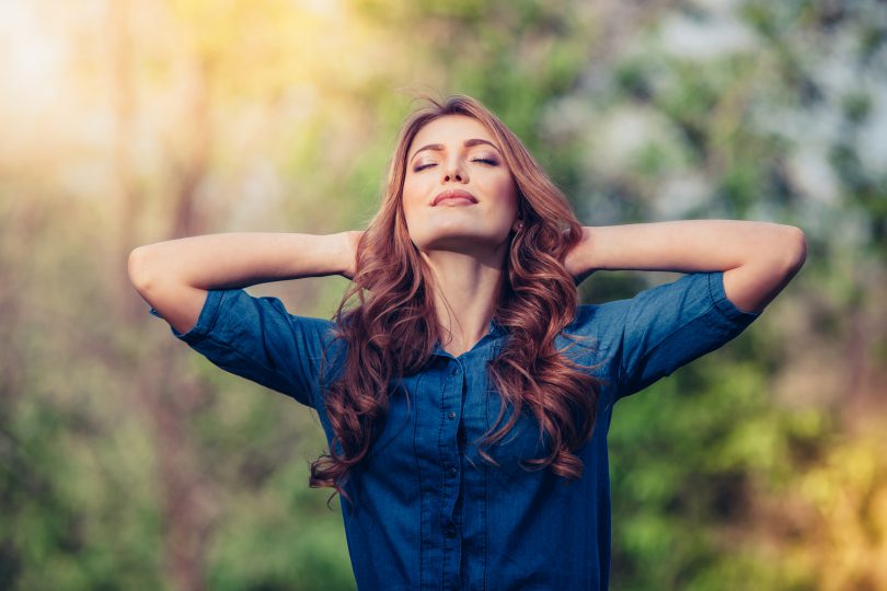 Free Happy Woman Enjoying Nature. Beauty Girl Outdoor. Freedom concept. Beauty Girl over Sky and Sun. Sunbeams. Enjoyment.