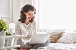 Happy casual beautiful woman working on a laptop sitting on the