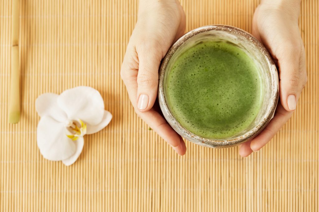 Organic green matcha tea top view. Matcha green tea on wooden table on background.