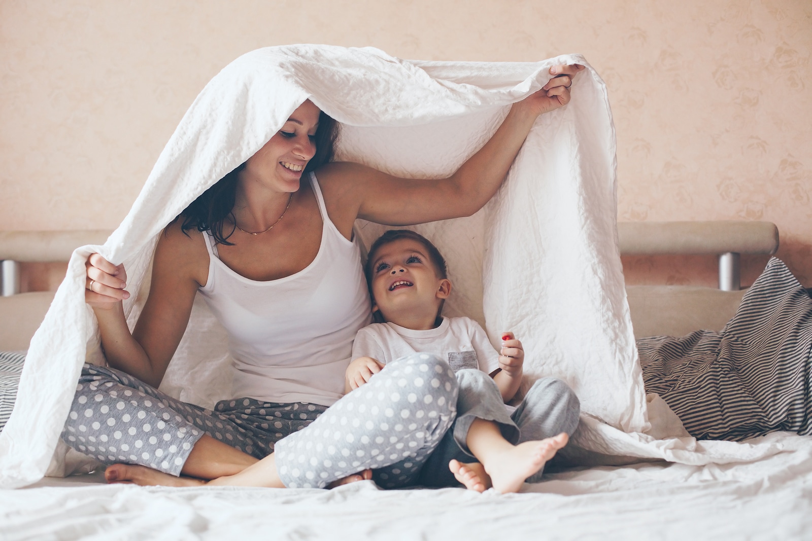 Young mother with her 2 years old little son dressed in pajamas