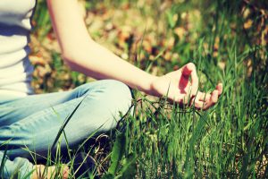 Young woman during relaxation and meditation in park meditation