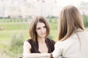 Attentive listener participating in two women conversation outdoors