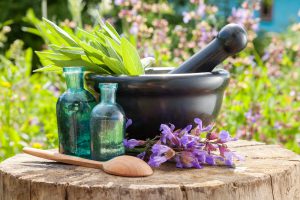 Black Mortar With Sage Herbs, Glass Bottles Of Essential Oil Out