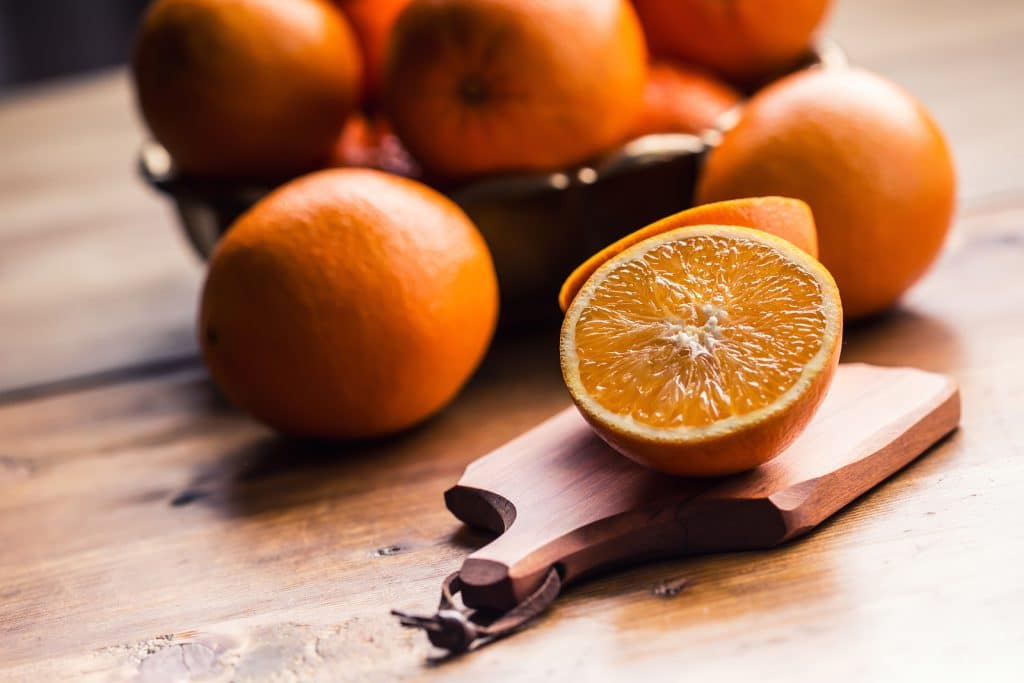 Fresh oranges. Cut oranges. Pressed orange manual method. Oranges and sliced oranges with juice and squeezer.