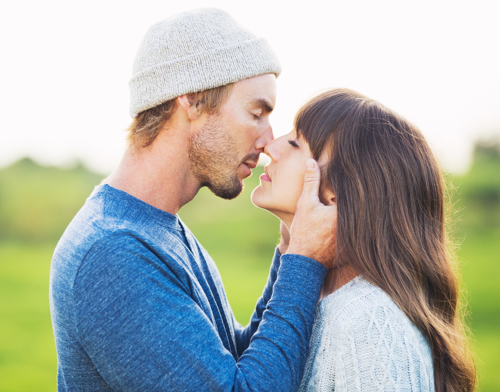 Happy Young Couple Having Fun Outdoors. Romantic Couple Kissing in Love on Country Road.